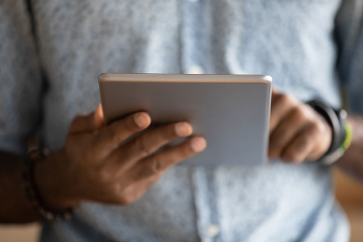 man uses hands to browse tablet