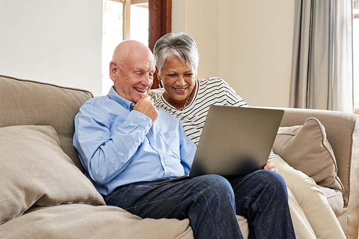 A senior couple enjoys a video call on their laptop