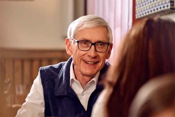 governor tony evers smiling sitting at a restaraunt